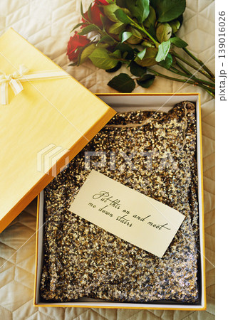 Box, flowers and invitation paper on bed, gift or dress in closeup, above or message on valentines day in hotel. Roses, bouquet or fashion in cardboard package, notes and letter in bedroom in home Box, flowers and invitation paper on bed, gift or dress in closeup, above or message on valentines day in hotel. Roses, bouquet or fashion in cardboard package, notes and letter in bedroom in home 139016026