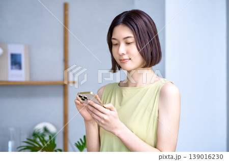 自宅でスマートフォンを操作する若い日本人女性 139016230