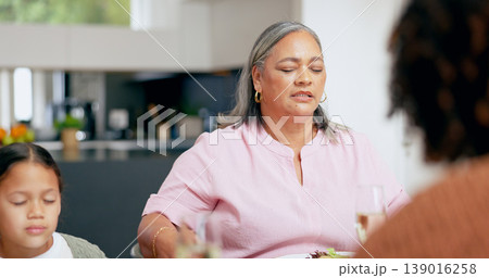 Praying, senior woman and family at table for dinner, lunch or breakfast and holding hands for grace. Christian, religion and grandmother with girl giving gratitude, prayer or thank you god for food 139016258