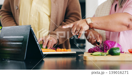 Senior, hands and cooking in kitchen with tablet for dinner, lunch or vegetables with support, help and love. Elderly, man and woman with pointing, peace and nutrition for bonding or relationship 139016271