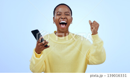 Woman, phone and wow for happy news, social media competition or giveaway success on a blue background. Portrait of African person with surprise, excited and yes for sale or bonus on mobile in studio Woman, phone and wow for happy news, social media competition or giveaway success on a blue background. Portrait of African person with surprise, excited and yes for sale or bonus on mobile in studio 139016331