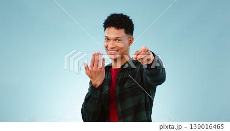 Man, pointing and invitation for welcome in studio, offer and choice on blue background. Model, happy face and hand gesture for sign up in promotion, deal opportunity and advertising for mockup space Man, pointing and invitation for welcome in studio, offer and choice on blue background. Model, happy face and hand gesture for sign up in promotion, deal opportunity and advertising for mockup space 139016465