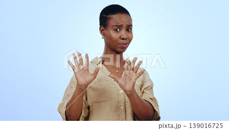 Black woman, fear and shock with hands for stop in studio on blue background for mock up. Portrait, female model and horror emoji for bad, reaction or expression on face for alarm, confused or scared 139016725