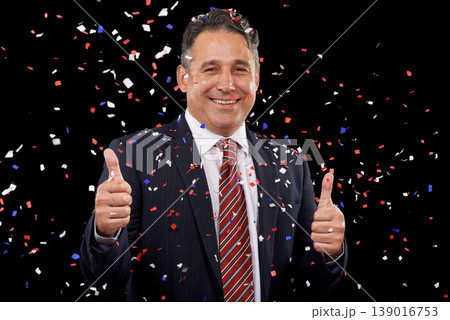 Business man, thumbs up and confetti for celebration, success and winning, thank you or support in election in studio. Portrait of professional winner in suit, like emoji and vote on black background 139016753