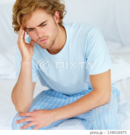 Stress, thinking and exhausted with a man on his bed in the morning to wake up feeling moody. Depression, mental health or burnout with a tired young person alone in the bedroom of his apartment 139016973