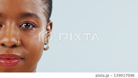 Mockup space, studio and portrait of black woman on blue background for news, information and beauty. Model, closeup and half face of African person with cosmetics, makeup and dermatology Mockup space, studio and portrait of black woman on blue background for news, information and beauty. Model, closeup and half face of African person with cosmetics, makeup and dermatology 139017096