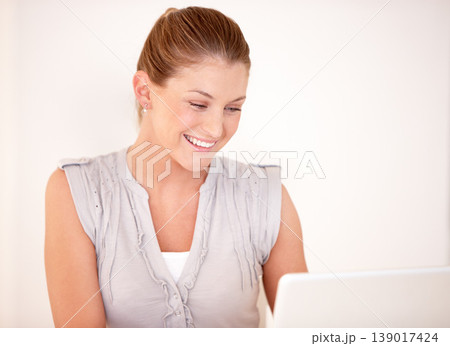 Laptop, happy and woman online in studio for research, internet and reading news on website. Smile, technology and person on computer for connection, networking and streaming on white background 139017424