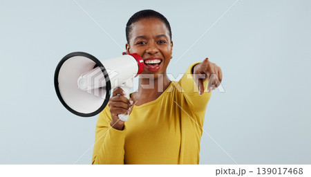 Happy black woman, portrait and pointing to you with megaphone for choice against a gray studio background. African female person smile with loudspeaker or bullhorn for selection, choosing or sale Happy black woman, portrait and pointing to you with megaphone for choice against a gray studio background. African female person smile with loudspeaker or bullhorn for selection, choosing or sale 139017468