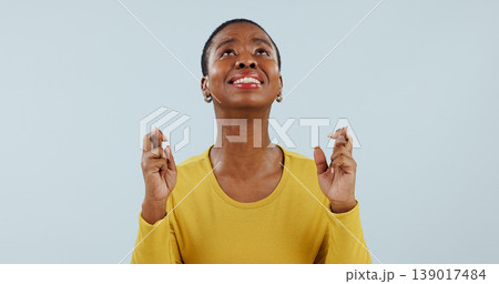 Hope, wish and black woman in studio with fingers crossed for opportunity, deal or good news prayer. Praying hands, thinking and person with winning dream, confidence and faith on white background. Hope, wish and black woman in studio with fingers crossed for opportunity, deal or good news prayer. Praying hands, thinking and person with winning dream, confidence and faith on white background. 139017484