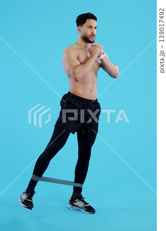 Man, legs and resistance band in workout, training or fitness against a blue studio background. Male person, athlete or serious model with straps for cardio exercise, endurance or stamina on mockup Man, legs and resistance band in workout, training or fitness against a blue studio background. Male person, athlete or serious model with straps for cardio exercise, endurance or stamina on mockup 139017492