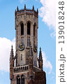 Sunny view of the Belfry of Bruges rising above the historic Markt square, showcasing medieval Flemish architecture under a clear blue sky, Brugge, West Flanders, Belgium 139018248