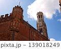 Sunny view of the Belfry of Bruges rising above the historic Markt square, showcasing medieval Flemish architecture under a clear blue sky, Brugge, West Flanders, Belgium 139018249