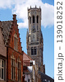 Sunny view of the Belfry of Bruges rising above the historic Markt square, showcasing medieval Flemish architecture under a clear blue sky, Brugge, West Flanders, Belgium 139018252