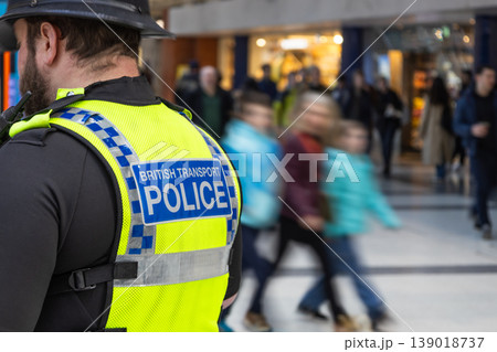 Police officer watching over a crowded public transport hub Police officer watching over a crowded public transport hub 139018737