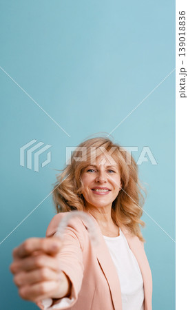 Mature woman smiling holding invisible braces on blue background Mature woman smiling holding invisible braces on blue background 139018836