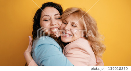 Happy mother and daughter embracing with closed eyes Happy mother and daughter embracing with closed eyes 139018850