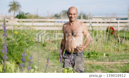 Happy man gardening fresh vegetables in urban community garden Happy man gardening fresh vegetables in urban community garden 139018912