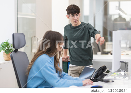 Colleagues collaborating on computer in modern office Colleagues collaborating on computer in modern office 139018924