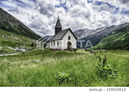 Small church standing on a green meadow, Italian Alps Small church standing on a green meadow, Italian Alps 139020018