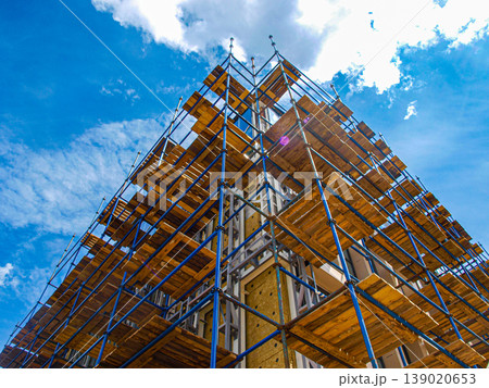 Modern building construction site with scaffolding. Unusual frame composition and architectural geometry with diagonal lines. Industrial structure, urban development and steel framework. 139020653