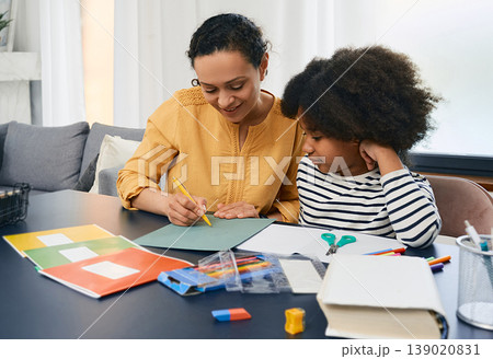 Family day. Mother helps her daughter do school homework while father works on his laptop. Happy family, home comfort Family day. Mother helps her daughter do school homework while father works on his laptop. Happy family, home comfort 139020831