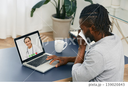 Adult man with handkerchief holds a medical online conference from home with his general practitioner for treating of his disease Adult man with handkerchief holds a medical online conference from home with his general practitioner for treating of his disease 139020843