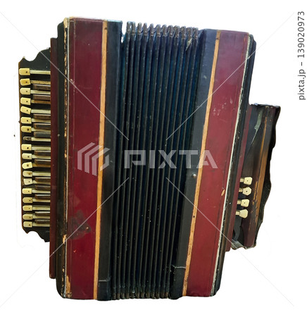 An old retro accordion sits alone against a white background. The instrument has visible keys and a worn finish. It shows signs of age and has a classic design that highlights its history. An old retro accordion sits alone against a white background. The instrument has visible keys and a worn finish. It shows signs of age and has a classic design that highlights its history. 139020973