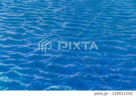 Rippling azure waters reflecting sunlight on a tranquil summer afternoon by the beach Rippling azure waters reflecting sunlight on a tranquil summer afternoon by the beach 139021202