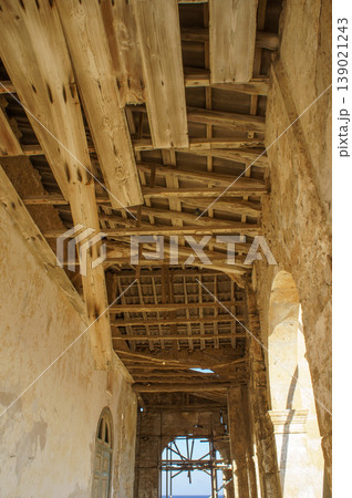 Exploring the rustic charm of an ancient building with wooden beams in serene daylight. 139021243