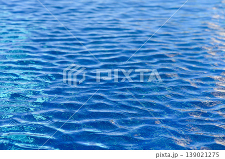 The tranquil beauty of shimmering water ripples under the sun on a serene day at the poolside oasis The tranquil beauty of shimmering water ripples under the sun on a serene day at the poolside oasis 139021275