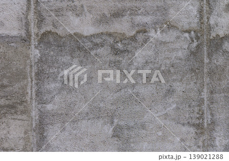 A textured concrete wall with subtle shading, revealing signs of wear and age in an urban setting 139021288