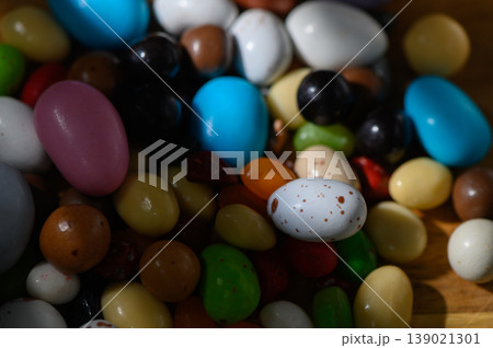 Colorful array of sweet candies in various shapes resting on a wooden surface 139021301