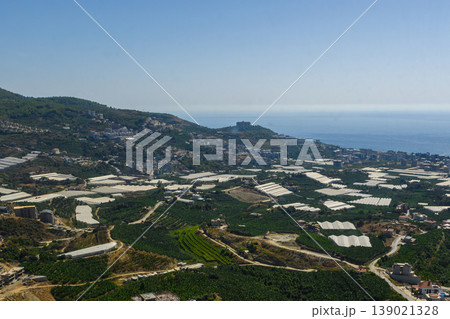 A breathtaking view of green fields and coastal landscape in a vibrant agricultural region under a clear blue sky A breathtaking view of green fields and coastal landscape in a vibrant agricultural region under a clear blue sky 139021328