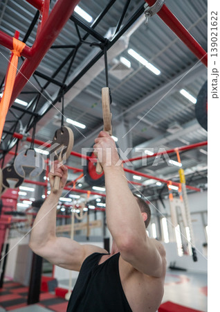 An athletic man practices at a ninja club's indoor obstacle course. An athletic man practices at a ninja club's indoor obstacle course. 139021622