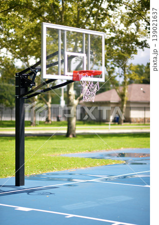 Calm Neighborhood Park Illuminated By Sunlight Showcasing Basketball Net And Rowhouses. New York Calm Neighborhood Park Illuminated By Sunlight Showcasing Basketball Net And Rowhouses. New York 139021637