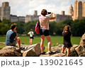 Relaxed Tourists Capturing Of Tall Buildings Against Soft Golden Sunlight In Park. New York 139021645
