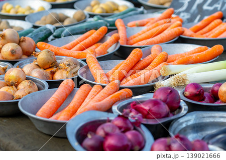 Carrots and onions for sale at a market stall Carrots and onions for sale at a market stall 139021666