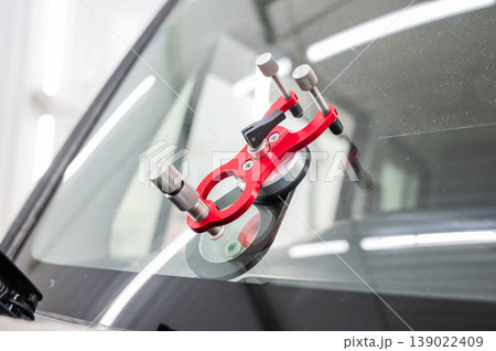 Repairing a chip on a car windshield.  139022409