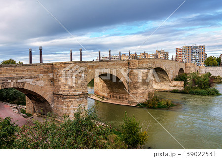 Old stone bridge Puente de Piedra over the Ebro river in the center of Zaragoza in Spain 139022531