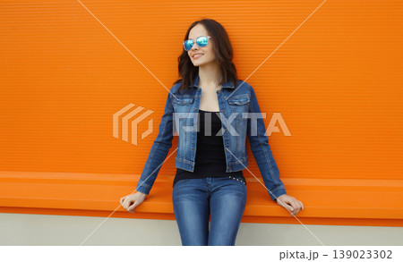Happy young woman, modern girl looking away posing on bright background Happy young woman, modern girl looking away posing on bright background 139023302