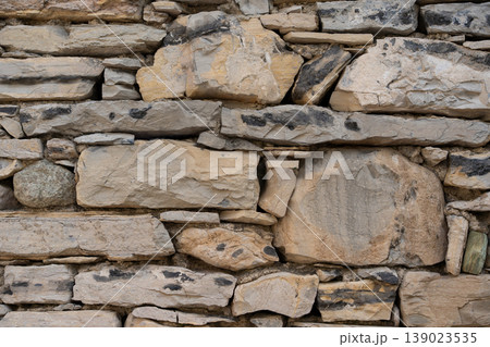 Light limestone fieldstone wall texture rustic natural masonry background closeup Light limestone fieldstone wall texture rustic natural masonry background closeup 139023535