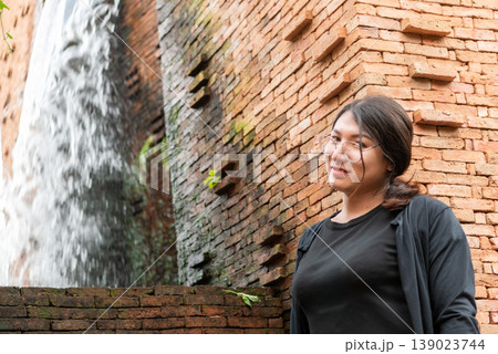 Young lgbtq woman wearing glasses standing by old brick wall outdoors natural light urban background calm expression identity diversity inclusion confidence lifestyle portrait Young lgbtq woman wearing glasses standing by old brick wall outdoors natural light urban background calm expression identity diversity inclusion confidence lifestyle portrait 139023744