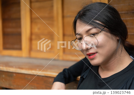 Close up of LGBTQ woman wearing glasses looking thoughtful indoors warm wooden background natural light lifestyle portrait calm confidence and authenticity Close up of LGBTQ woman wearing glasses looking thoughtful indoors warm wooden background natural light lifestyle portrait calm confidence and authenticity 139023746