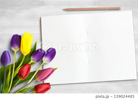 Colorful tulip flower,blank notebook and pencil on white wood table background. Colorful tulip flower,blank notebook and pencil on white wood table background. 139024485