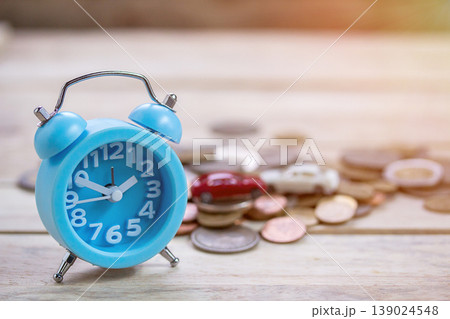 Coins and blue alram clock on wood table background. 139024548