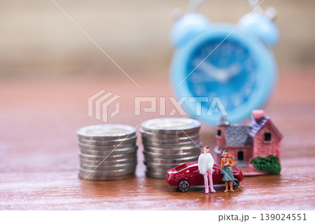 Miniature people: Businessman and women standing with step of coin money and toy car. Miniature people: Businessman and women standing with step of coin money and toy car. 139024551