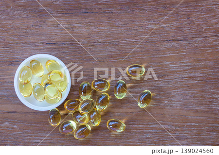 Omega 3 fish liver oil capsules on wooden background. Omega 3 fish liver oil capsules on wooden background. 139024560
