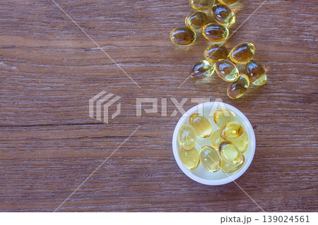 Omega 3 fish liver oil capsules on wooden background. Omega 3 fish liver oil capsules on wooden background. 139024561