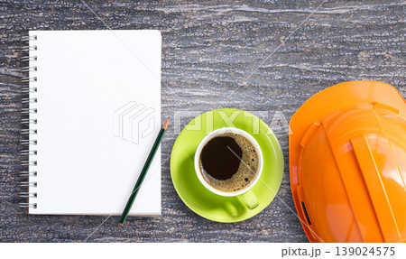 Top view with orange safety helmet, blank notepad and pencil on wooden Top view with orange safety helmet, blank notepad and pencil on wooden 139024575