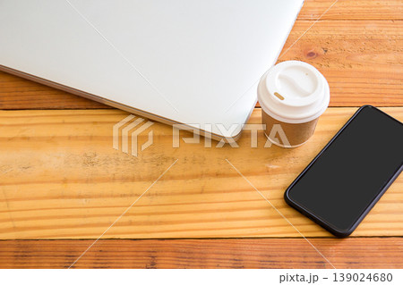 Top view of laptop computer,smartphone and cup of coffee on wood table background. Top view of laptop computer,smartphone and cup of coffee on wood table background. 139024680